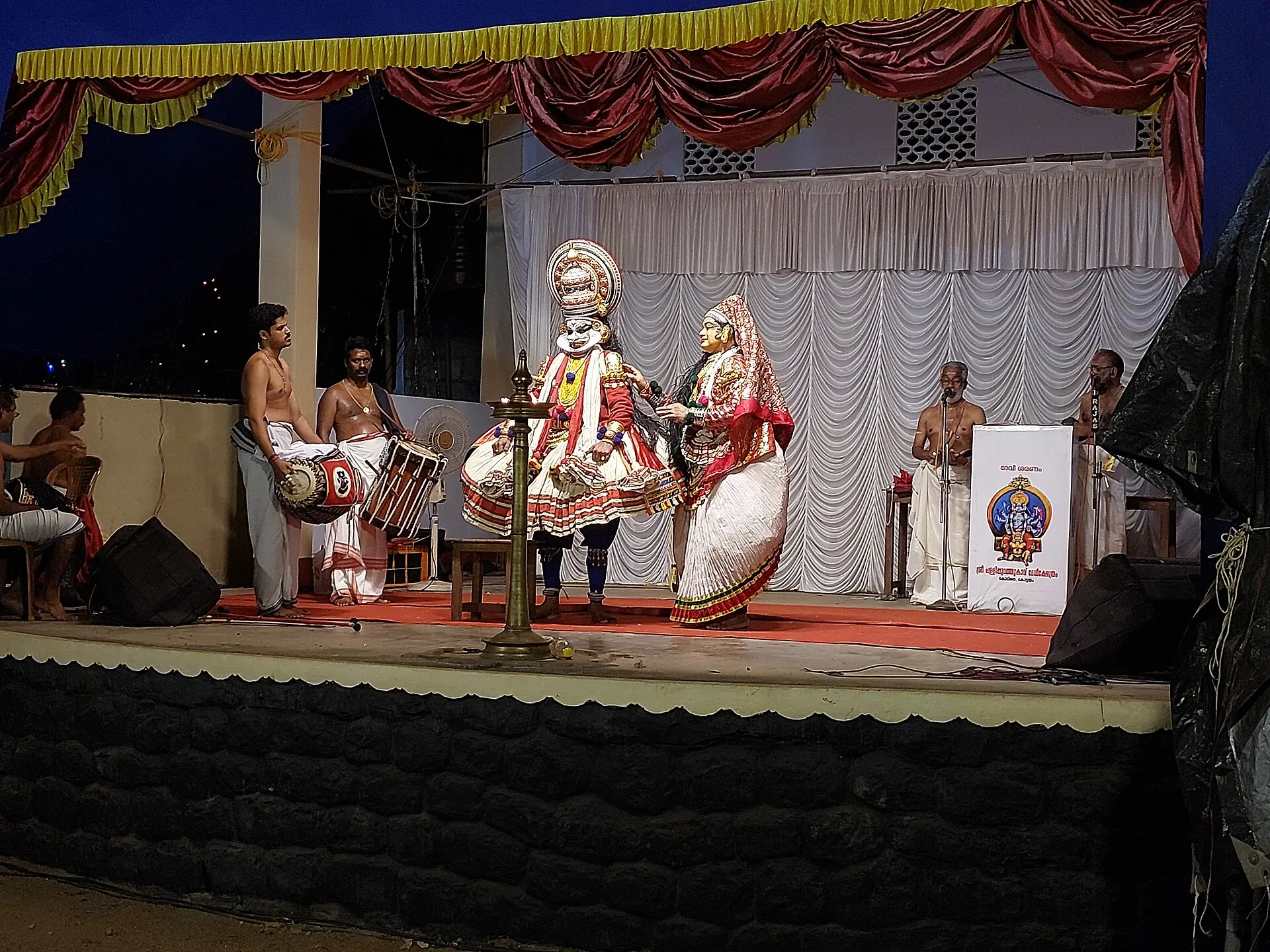 Kathakali performers in elaborate costume and painted faces on stage
