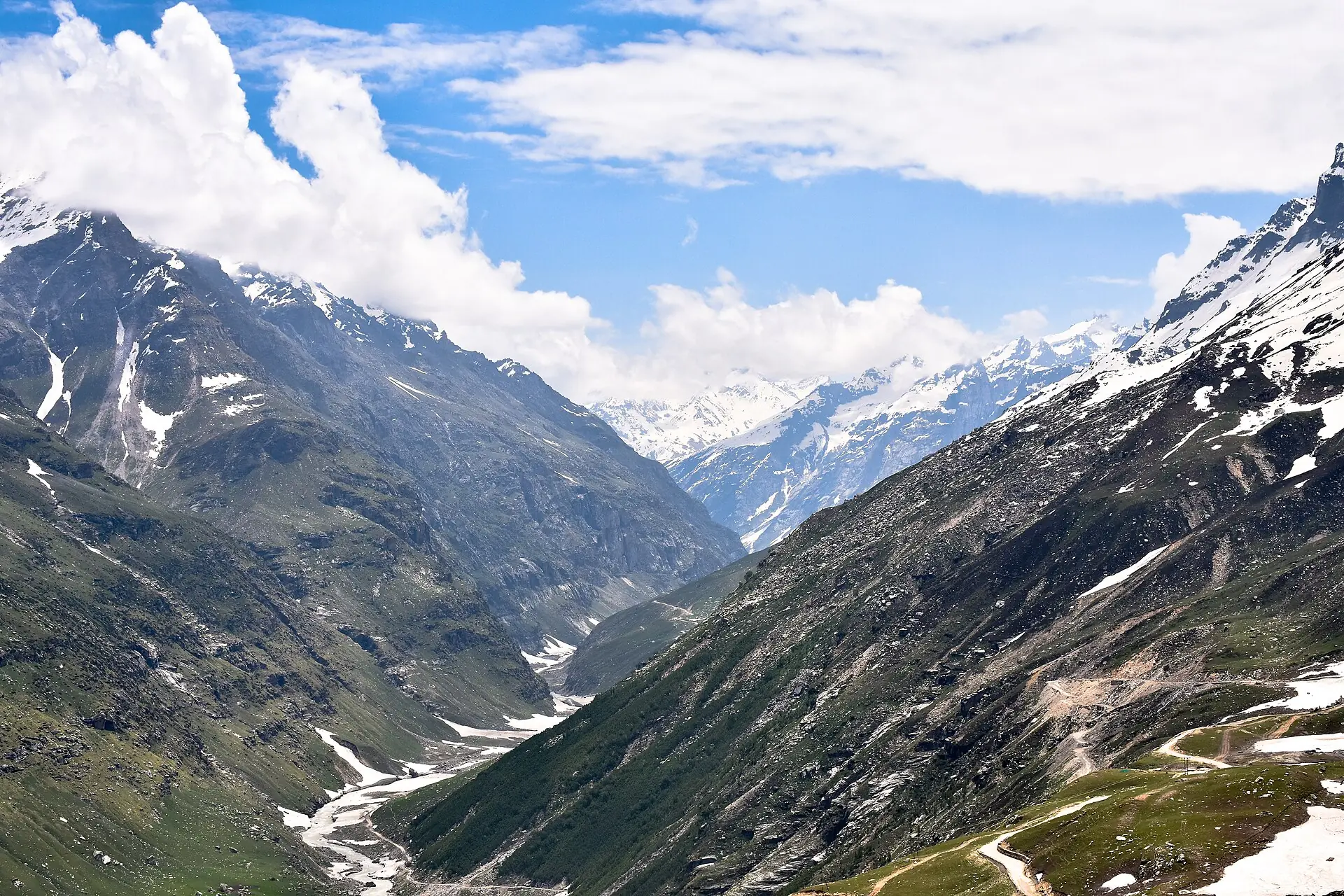 Deep mountain valley with a winding river below snow-streaked peaks, seen from Rohtang Pass