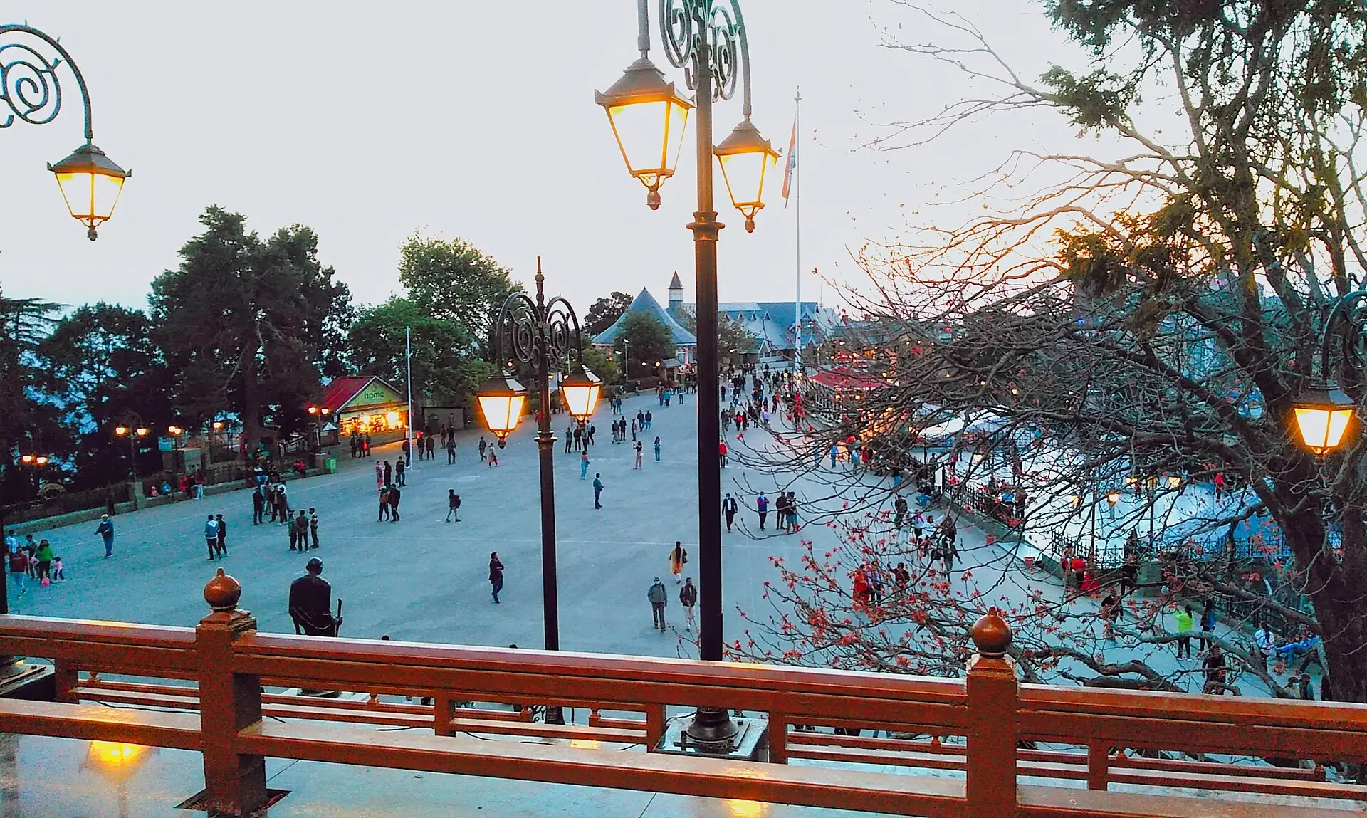 Lamp posts and people strolling along The Ridge in Shimla at dusk