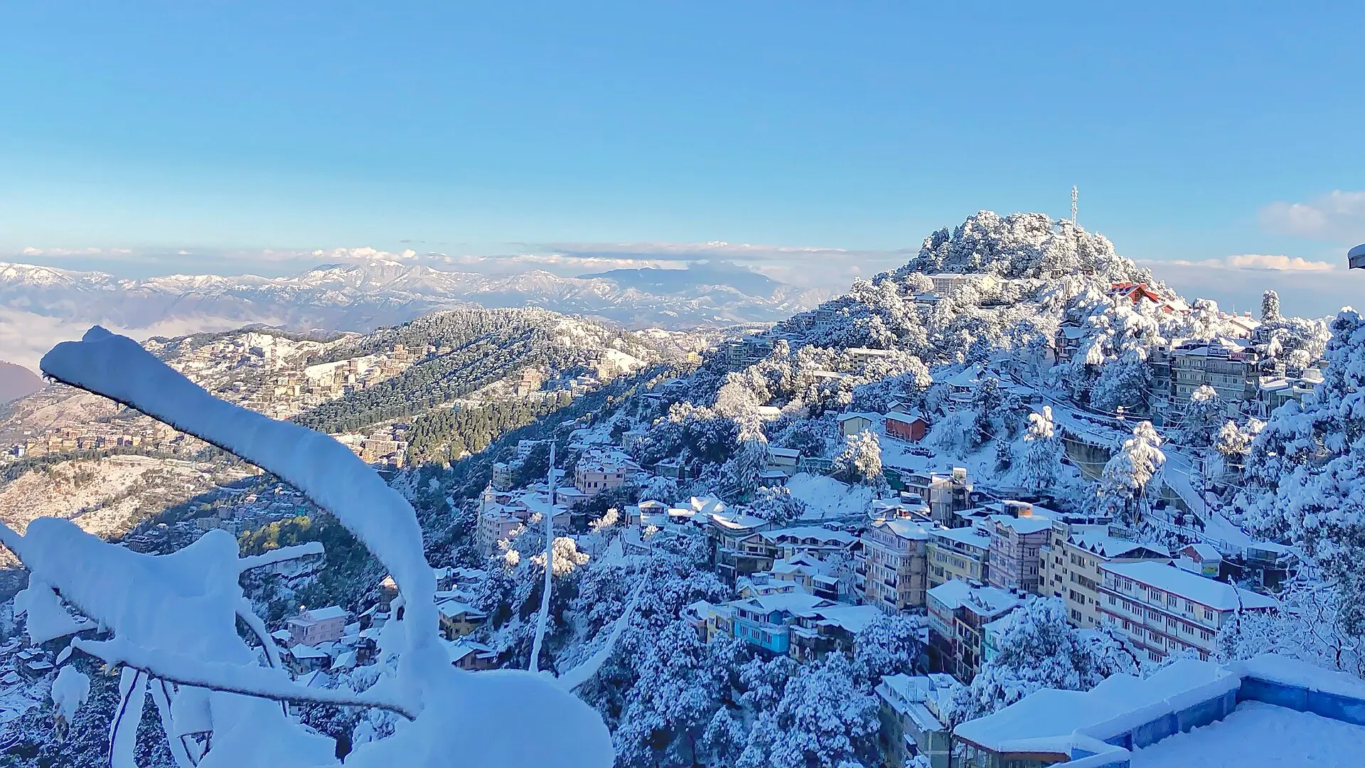Snow-covered hillside houses and trees of Shimla seen from the Ridge